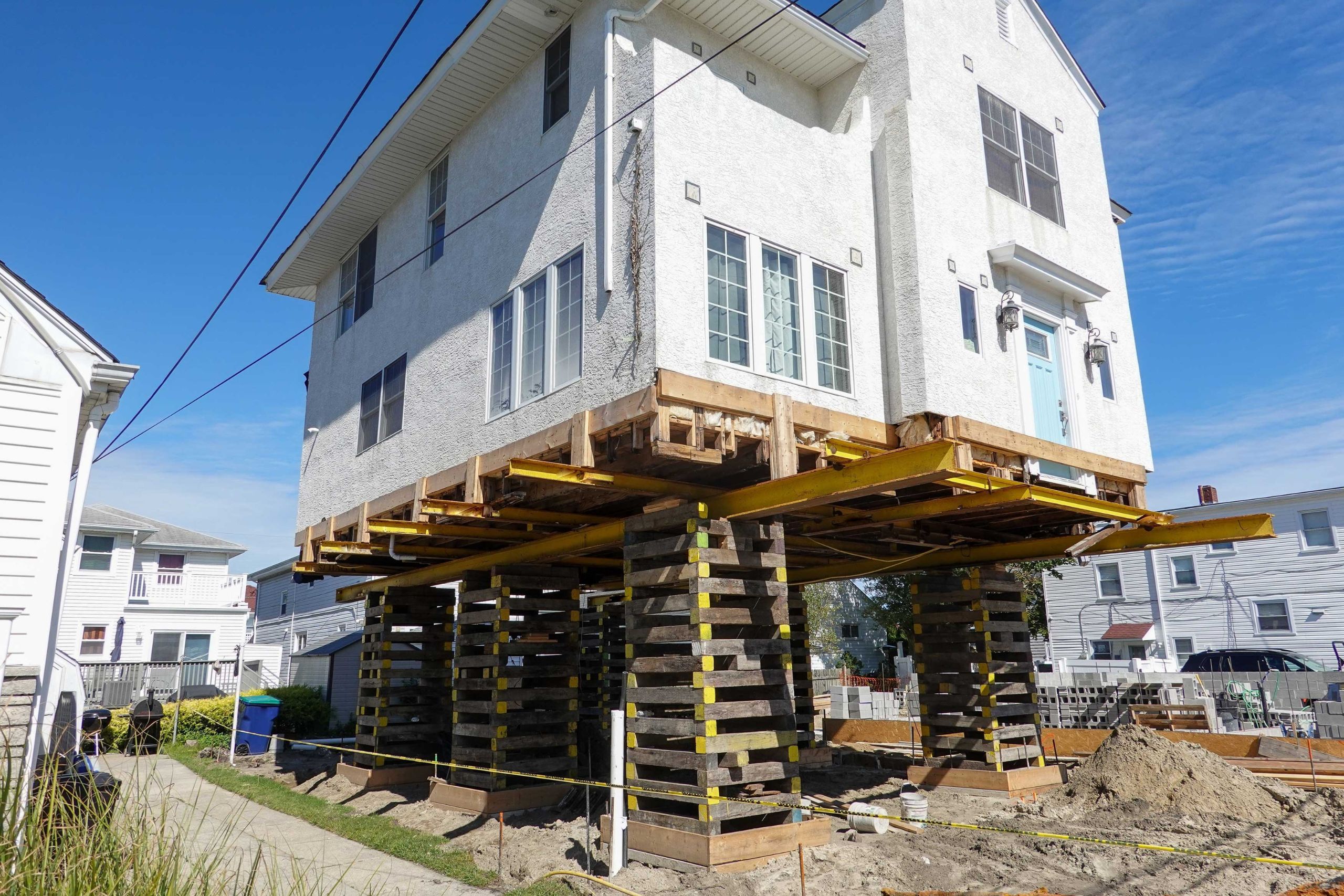 A team of professionals using specialized equipment to raise a house in Saint Augustine, preparing it for elevation and renovation